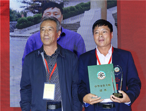 中華木工委專(zhuān)家委員會(huì)專(zhuān)家李永革（左）為楊俊平（右）頒授“中華木作大師”榮譽(yù)